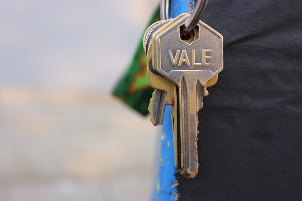 Services A detailed view of a metallic key with Vale engraved on it, hanging against a blurred background.